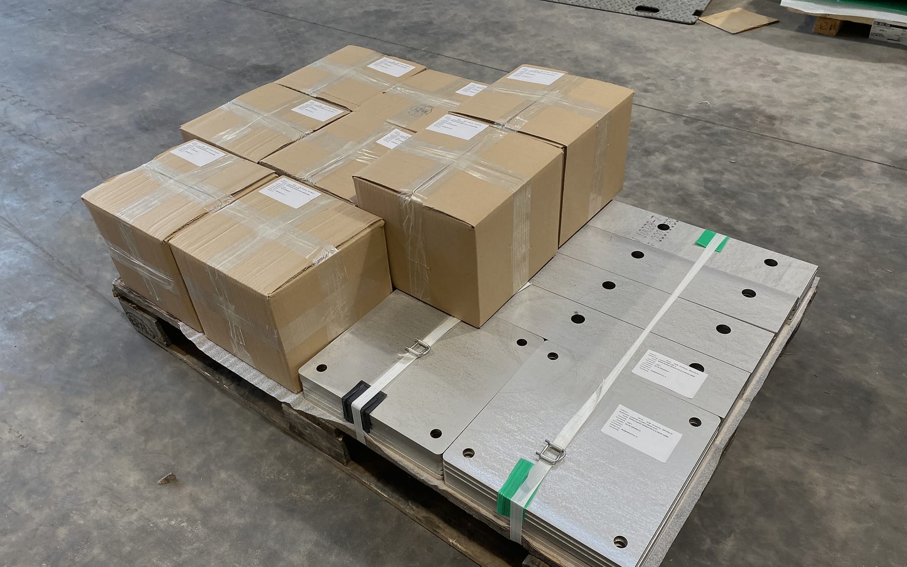 Sortenrein verpackte Laserteile mit Etiketten auf Palette